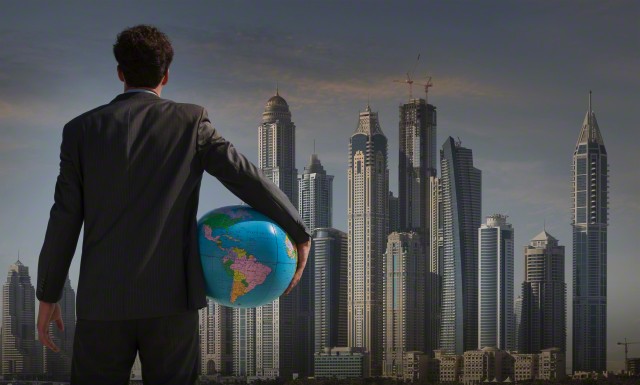 businessman holding globe near Qatar cityscape, Qatar